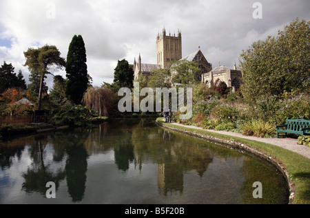 Wells Cathedral reflected in the wells, from which the city gets its name, inside the grounds of the Bishops Palace