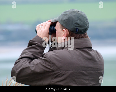 A bird watcher looking through binoculars Stock Photo