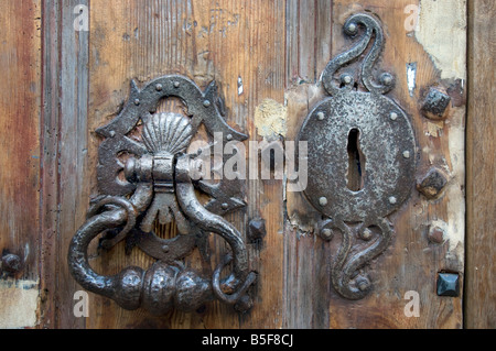 An ancient door knocker and lock on a battered old house door in Boulogne France Stock Photo