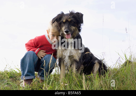 Little boy (3-4) playing with dog Stock Photo