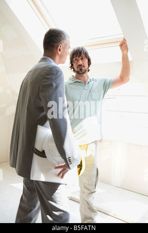 Two men talking at construction site Stock Photo