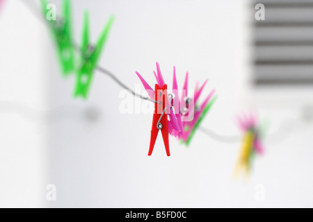 Colourful cloth pegs hanging on a wire Stock Photo