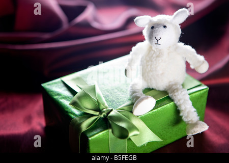 White toy sheep sitting on a gift box Stock Photo