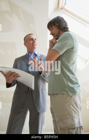 Two men looking at construction plan Stock Photo