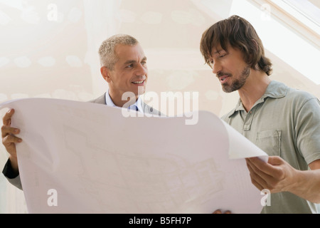 Two men looking at construction plan, portrait Stock Photo