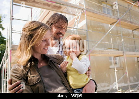 Young family in front of New Home Under Construction Stock Photo