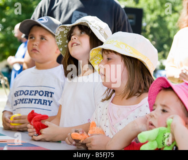 Four children watching a wheel of fortune at a carnival. Stock Photo