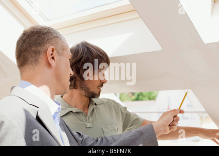 Two men, one holding pencil Stock Photo