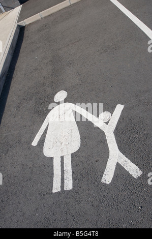 Road marking in an empty car parking space showing that it is reserved for parents with children to park only Stock Photo