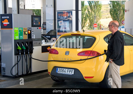 Customer putting fuel in his car at a gas station along the Autopisa near Pamplona Navarre northern Spain Stock Photo