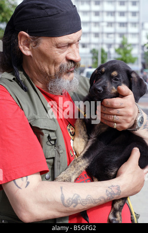 Elderly man holding a puppy Stock Photo