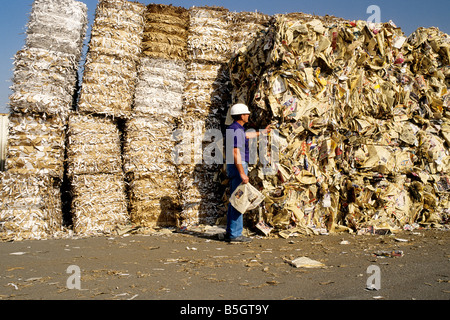 Worker wearing hard hat, recycle center. Stock Photo