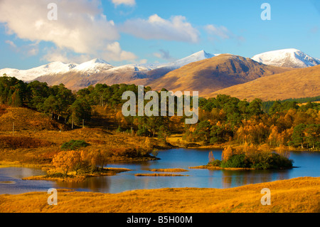 Looking over Loch Dochard near Rannoch Moor scotland with snow covered mountains in the distance
