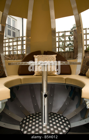 A modern urban designer garden with a spherical theme and a 'pod' seating structure Stock Photo