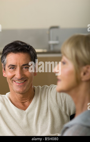 Mature man smiling at camera, woman in foreground Stock Photo