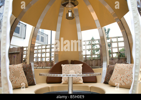 A modern urban designer garden with a spherical theme and a 'pod' seating structure Stock Photo