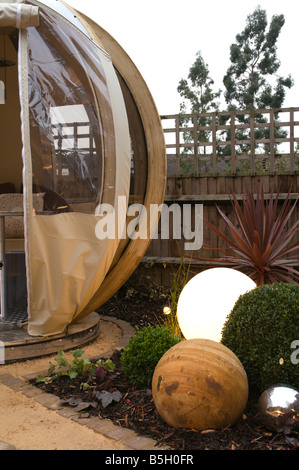 A modern urban designer garden with a spherical theme and a 'pod' seating structure Stock Photo