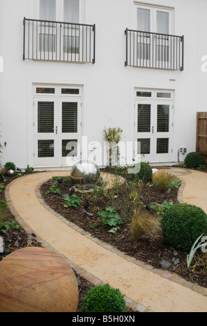 A modern urban designer garden with a spherical theme and a 'pod' seating structure Stock Photo