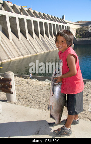 Colville Tribe Native American Indian boy holding a Chinook Salmon at Chief Joseph Dam in Washington Stock Photo