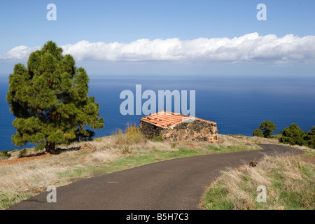 A hut by the side of a remote rural road on La Palma, one of the Canary Islands with the clouds of the trade winds on the horizo Stock Photo