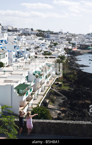dh  PUERTO DEL CARMEN LANZAROTE Tourist Holidaymaker women couple overlook old harbour and flats Stock Photo