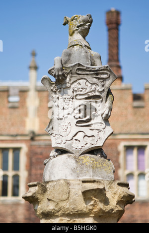 Stone statue holding a crest outside the front entrance of Hampton Court Palace Stock Photo