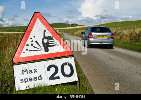 dh Roadsign ROAD UK Lose chippings warning sign 20 mph max speed car on road speeding limit traffic signage red triangle scotland Stock Photo