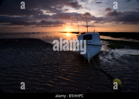 A small boat aground on a spectacular summer dawn, Robin Hoods Bay, North Yorkshire Stock Photo