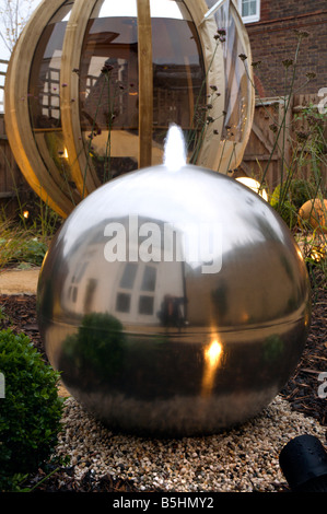 A modern urban designer garden with a spherical theme and a 'pod' seating structure Stock Photo