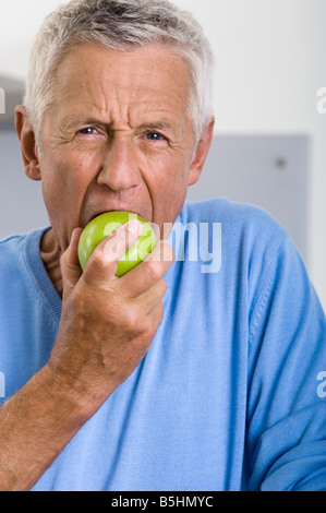 Senior man eating an apple Stock Photo