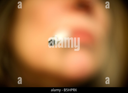 Woman Smoking in a restrictive focus image with a woman's face and mouth Stock Photo