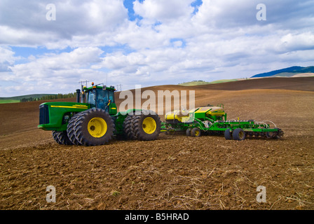 A tractor pulls an air seeder to plant grains or legumes in the spring in the Palouse region of Washington Stock Photo