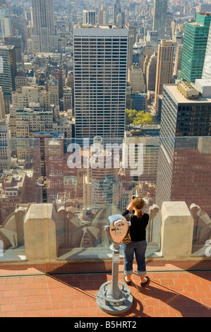 Tourist photographs Manhattan from exterior viewing platform at the top of the Rockefeller Centre, New York. Stock Photo