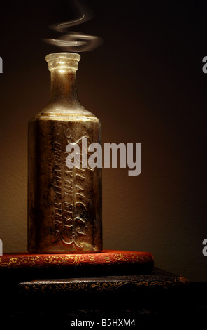 Antique books and bottle with 'magic potion' lighting effect. Stock Photo