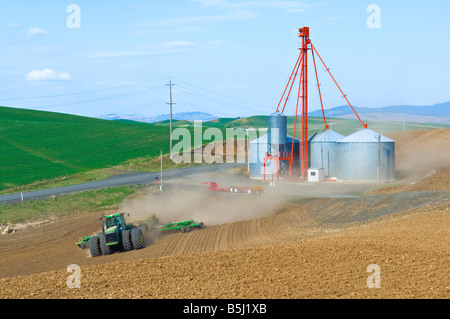 A tractor pulls an air seeder to plant grains or legumes in the spring in the Palouse region of Washington Stock Photo