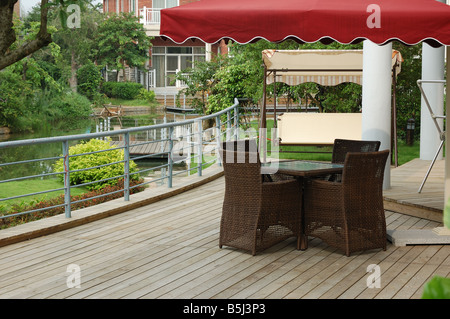 House backyard with table and chairs by a small river Stock Photo