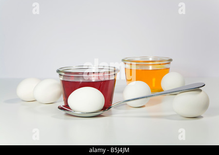 Easter eggs beside glasses of dye Stock Photo