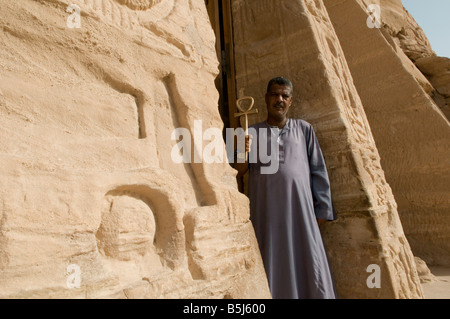 A guard holds an object in shape of ancient Egyptian hieroglyph symbol known as Ankh 'The Key of Life' in Abu Simbel rock temples. Southern Egypt Stock Photo