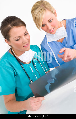 A female doctor with her colleague examining the x ray of a hip replacement Stock Photo