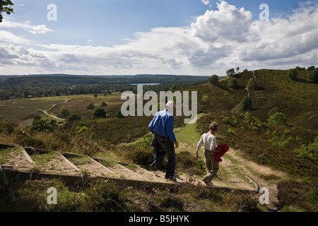 Couple walking on Stovbjerg hill and view to Sindbjerg hill and lake Brassø, near Sejs, Jutland, Denmark Stock Photo