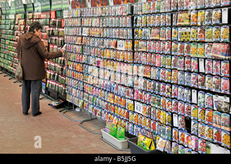 Woman shopping for seed packets in garden centre Stock Photo