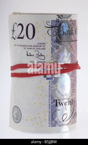 wad of 20 pounds sterling bank notes cash tied up in a roll with elastic band Stock Photo