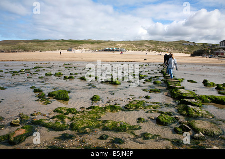 Walking over stepping stones across a stream on Perran sands beach in Perranporth, Cornwall UK. Stock Photo