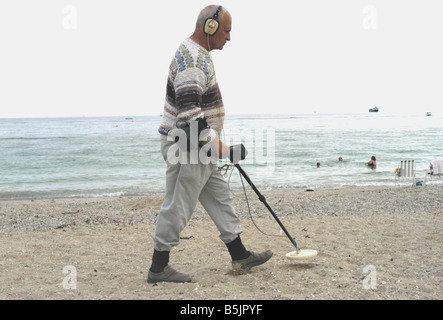 a man with a metal detector on a Cornish beach Stock Photo