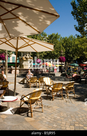 sitting out in the sunshine under parasols in the sun in French market square Place Carnot Carcassonne Stock Photo