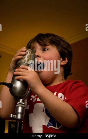 Young boy sings in an old microphone Stock Photo