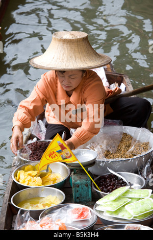 Damnoen saduak Floating Market, a bygone way of life in Ratchaburi. A  popular floating market with vendors in wooden boats on waterways in Thailand. Stock Photo