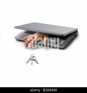hand emerging from a closed pc laptop trying to steal a key Stock Photo
