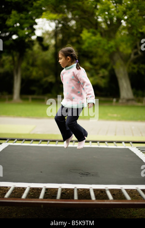 Five year old girl bouncing on a trampoline Stock Photo