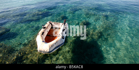 Abandoned fishing paddle boat on sand of sea bay. Quiet sea water level  within morning windless Stock Photo - Alamy